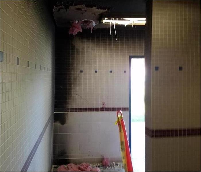 School bathroom showing considerable fire and soot damage