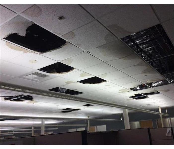 Business building showing the ceiling with tiles missing after falling down due to water damage